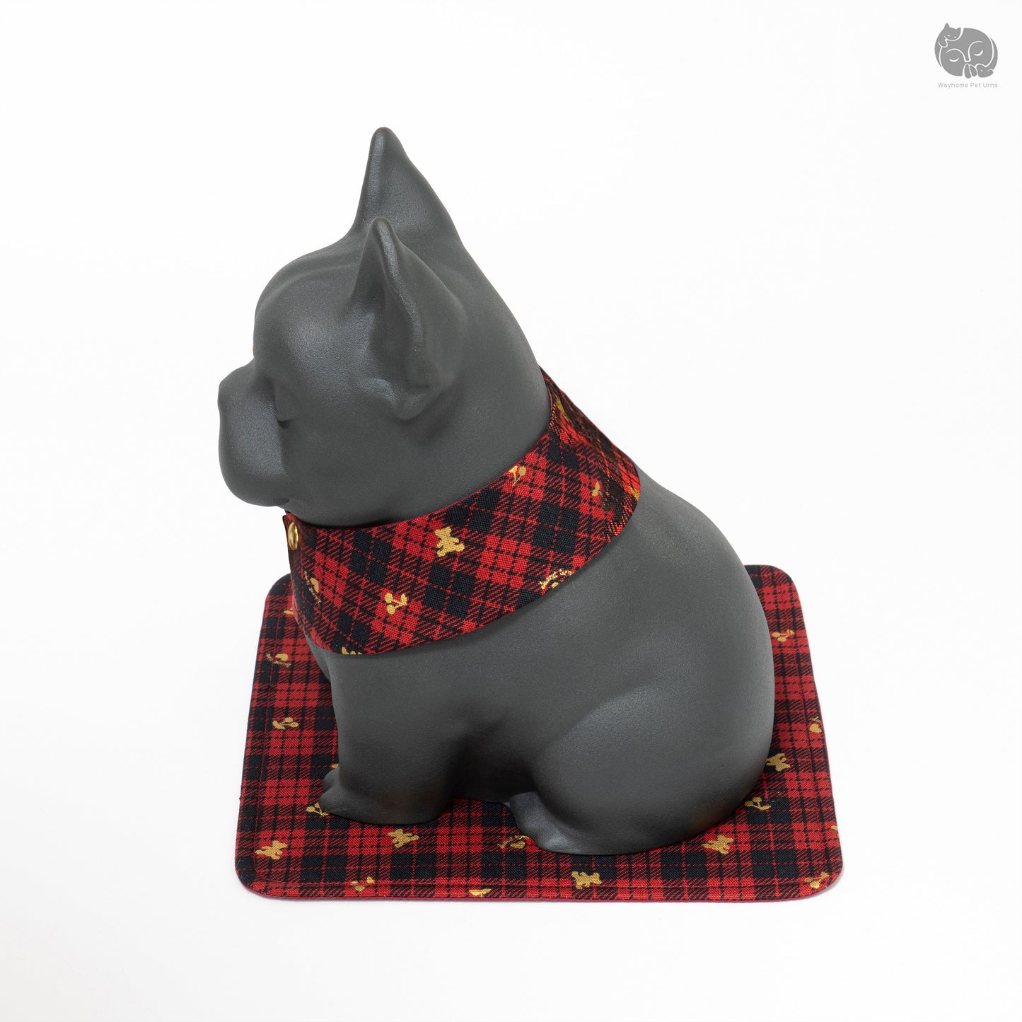 Angled back view of the handcrafted ceramic pet ashes jar on a traditional red plaid mat.