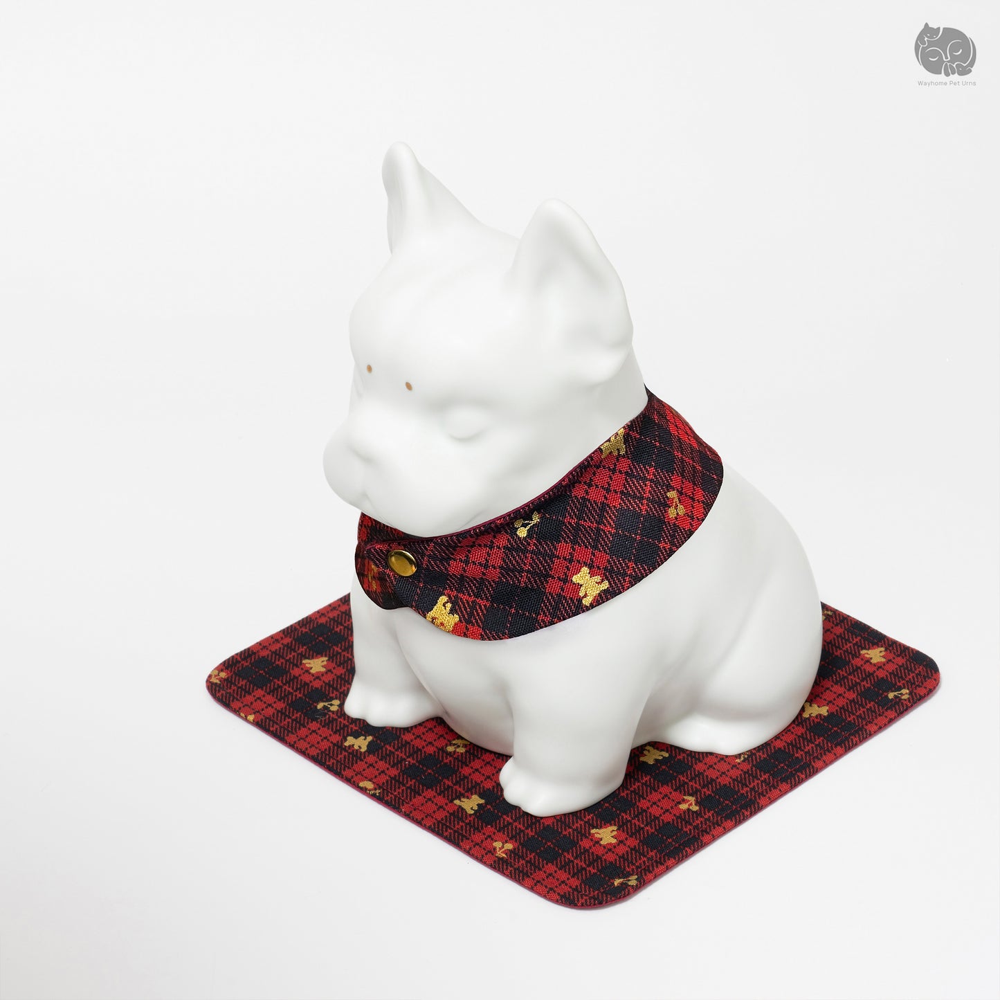 Low angle close-up of the Wayhome white ceramic bulldog memorial urn on its signature red mat.
