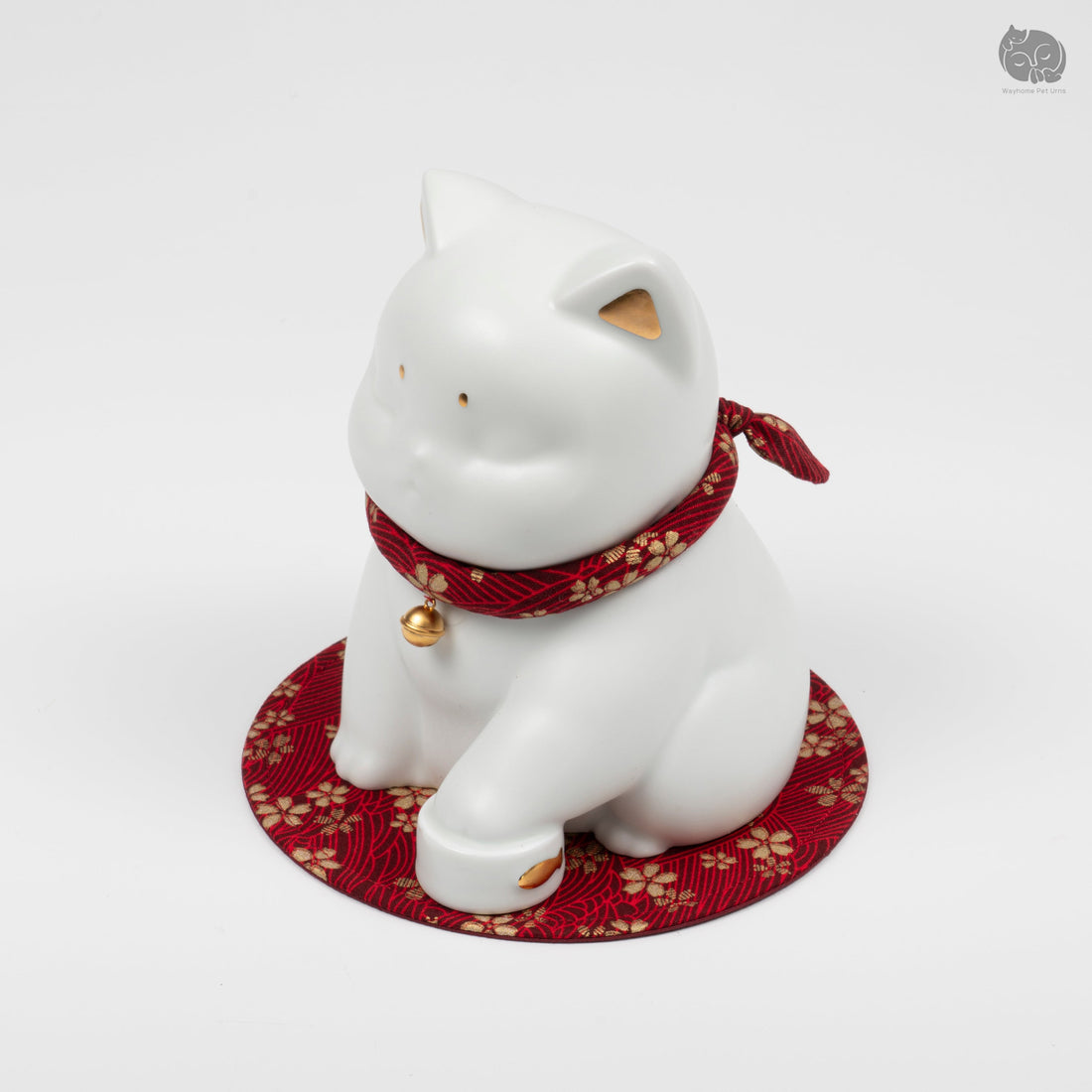 Three-quarter view of an ivory white ceramic cat urn showing its smooth surface, collar, and base