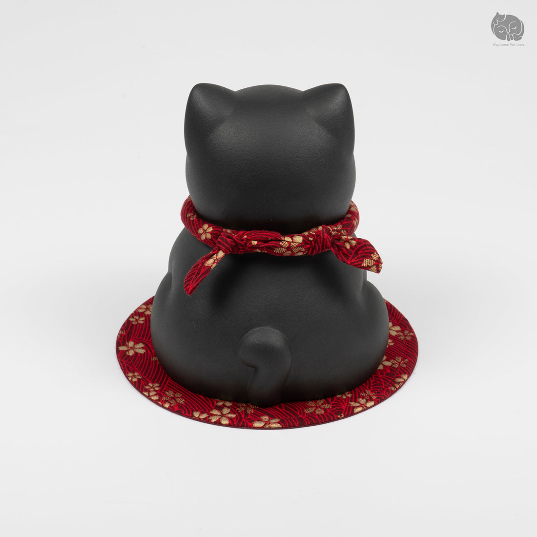 Rear view of an Obsidian Black ceramic cat urn on a red patterned mat