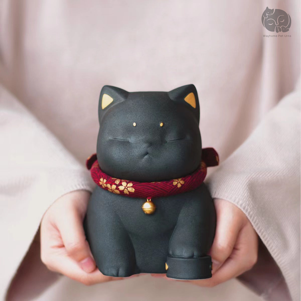 Wayhome obsidian black ceramic cat urn held in hands to show actual size and premium matte finish.