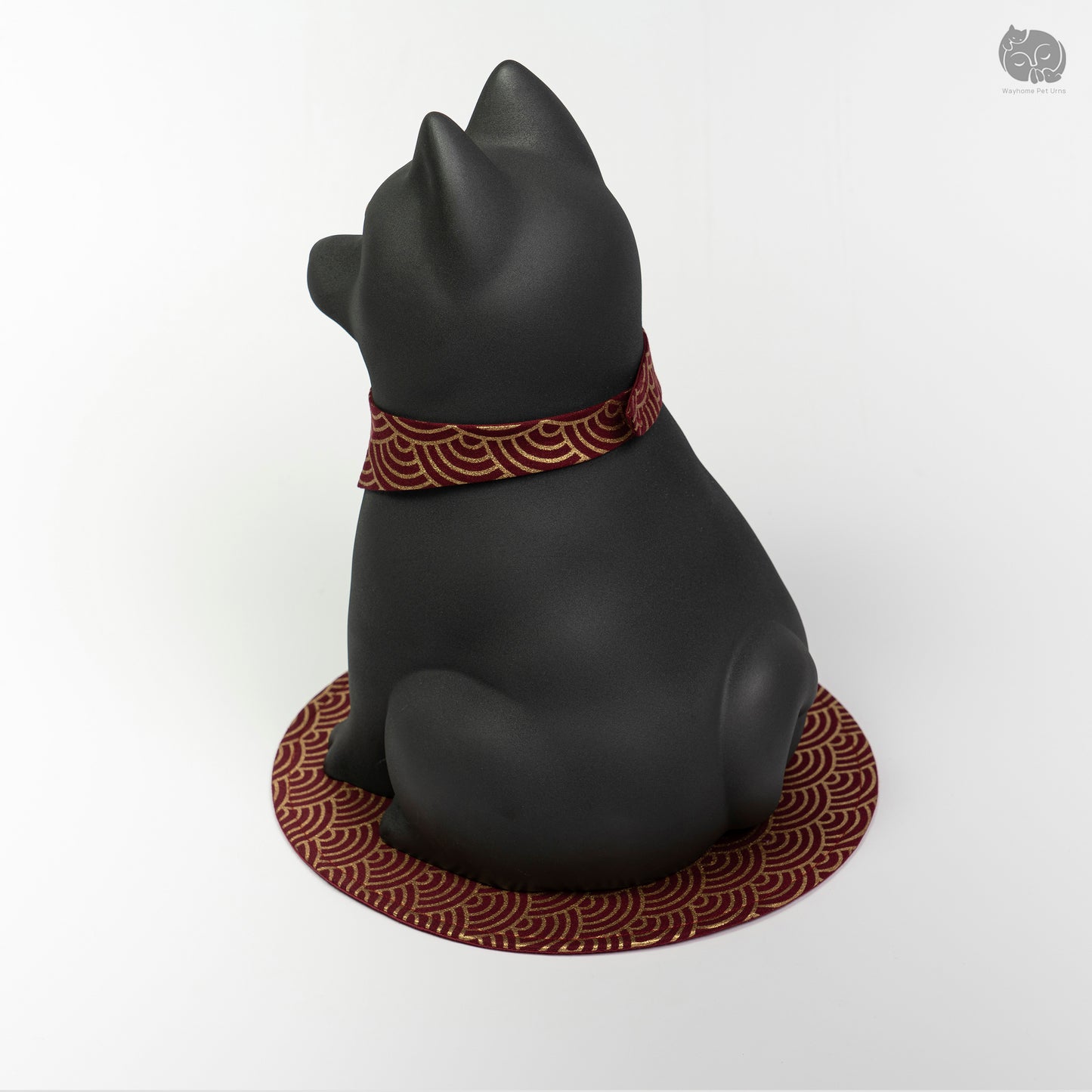 Rear quarter view of the obsidian black dog urn, showing the calm expression and sturdy handcrafted base.