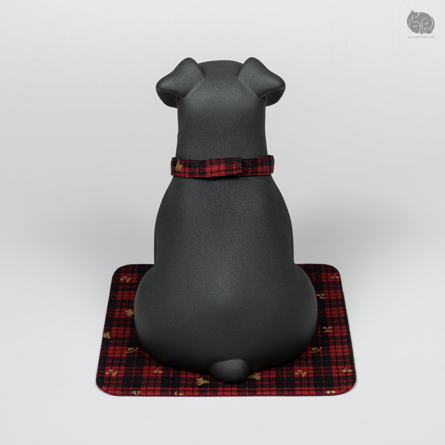 Rear view of the black ceramic Terrier urn on a decorative mat, showing the minimalist and sturdy design.
