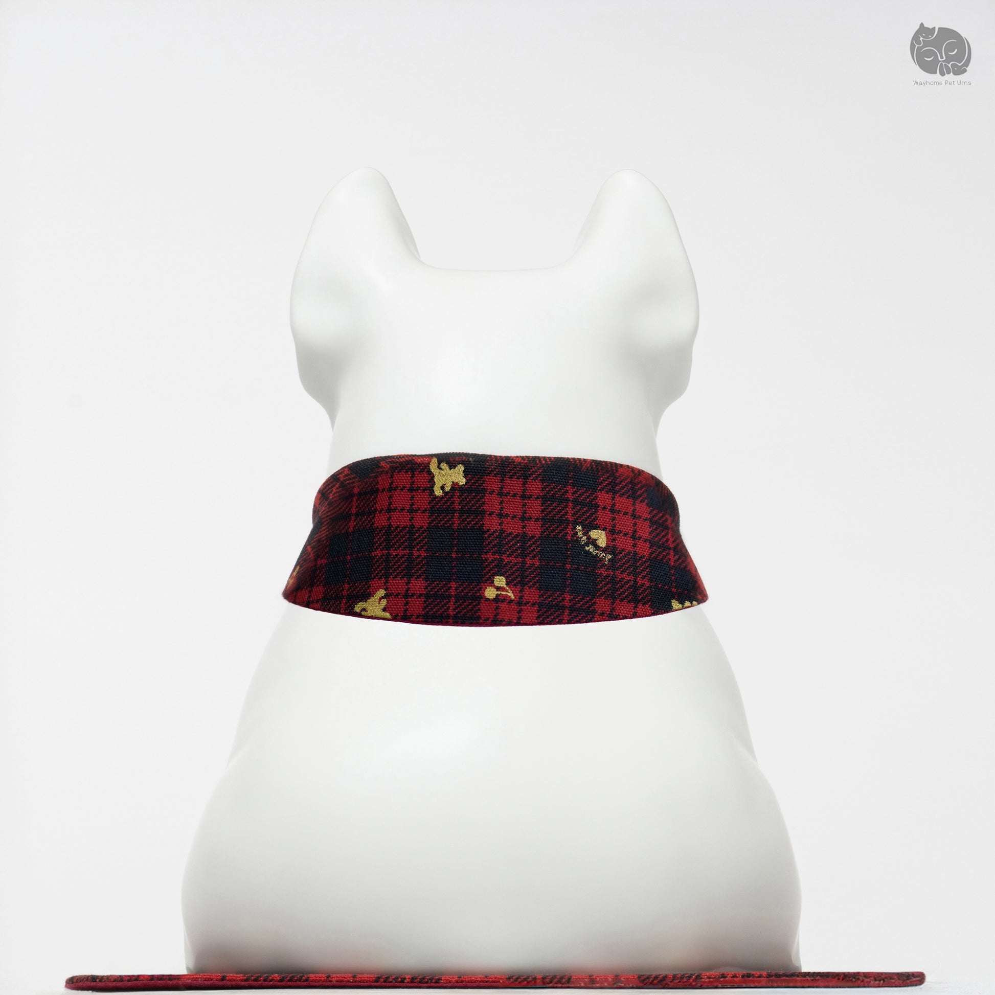 Back view of the Wayhome ivory white ceramic keepsake urn on a traditional red plaid mat.