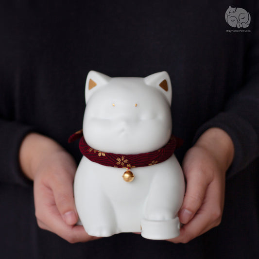 Wayhome ivory white handmade ceramic cat urn held in hands to show actual size and smooth matte texture.