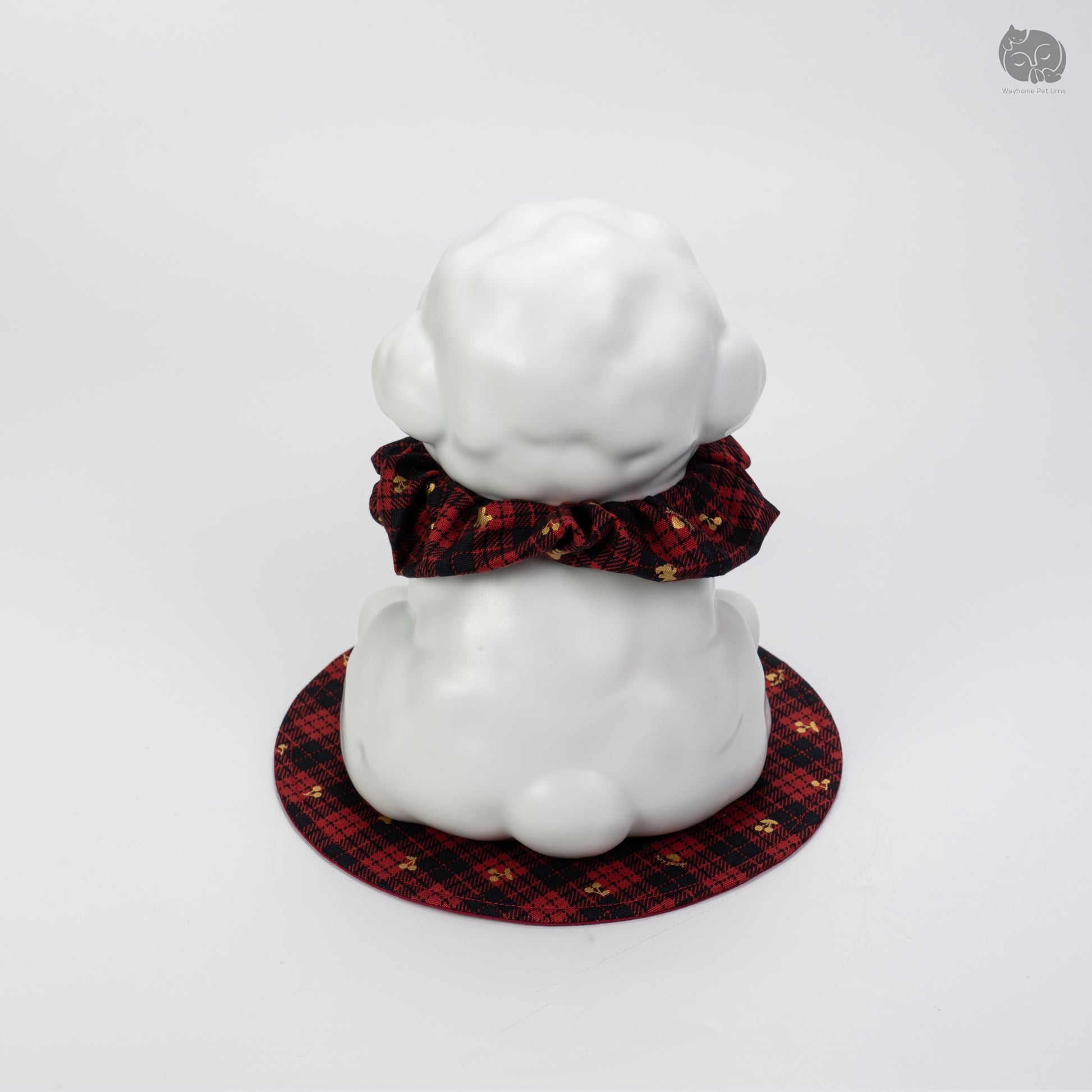 Top-down rear view of the white ceramic poodle urn on a decorative mat, showing the peaceful artisan design.