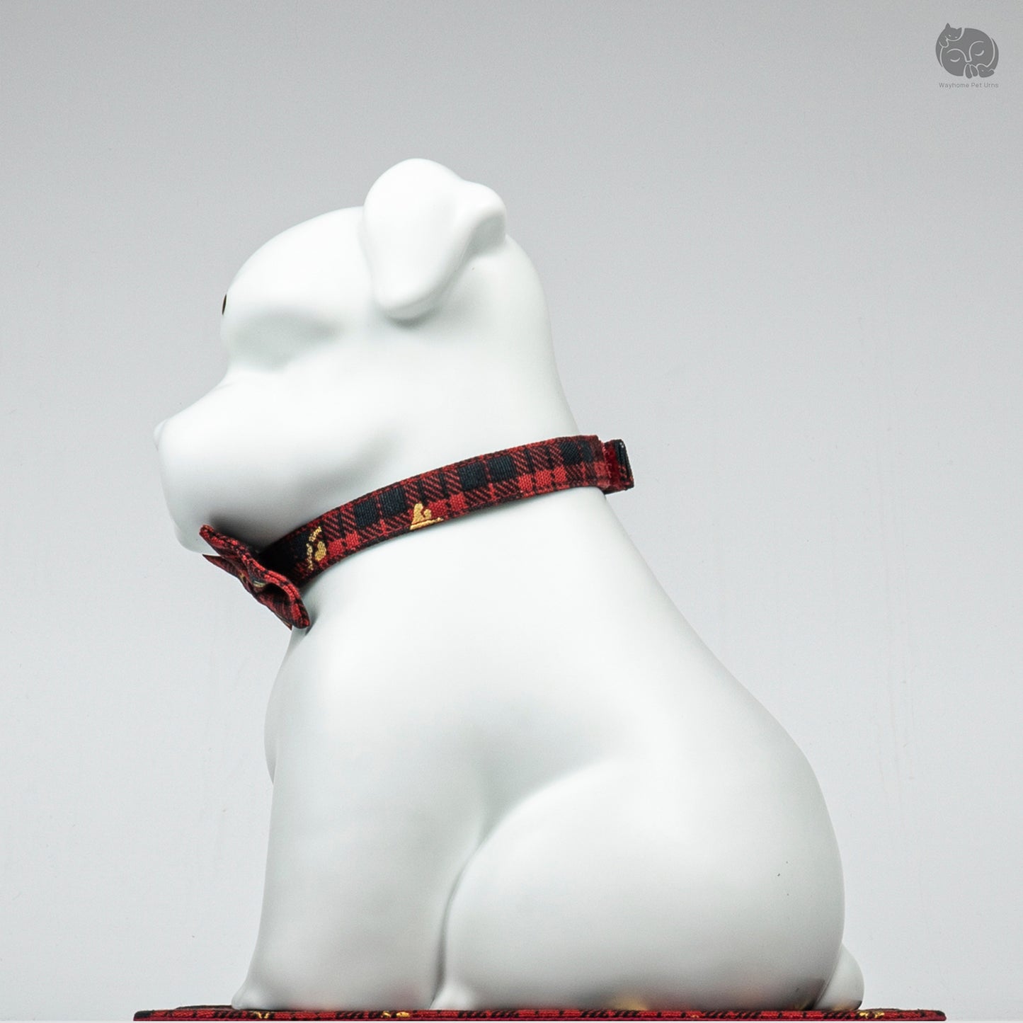 Side angle view of the ivory white Terrier memorial urn on a decorative mat, highlighting the peaceful sculpture.